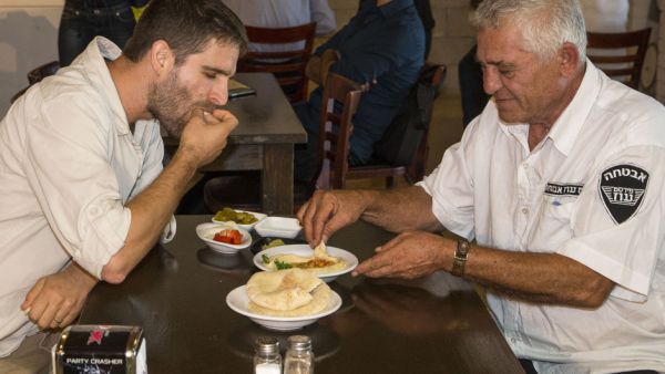 Two men share a plate of hummus at the Hummus bar. (AFP/File) 