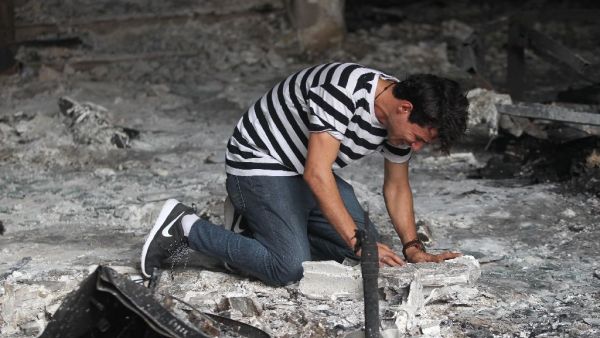 An Iraqi man reacts as he enters a building that was destroyed in a suicide-bombing attack in Baghdad's Karrada neighbourhood (AFP/Ahmad al-Rubaye)