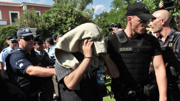 A Greek police officer escorts a Turkish soldier who fled to Greece by helicopter after a fail coup in July 2016. (AFP/File)
