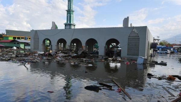 The standing remains of a mosque is seen amid waters from a tsunami surge in Palu, Indonesia's Central Sulawesi on September 30, 2018, following the September 28 earthquake and tsunami. (ADEK BERRY / AFP)