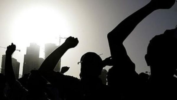 متظاهرون يرفعون قبضاتهم في الهواء في ساحة اللؤلؤة في وسط المنامة