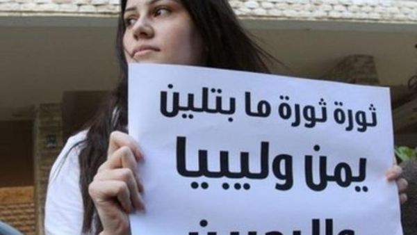 متظاهرة تحمل لافتة امام السفارة البحرينية في لبنان