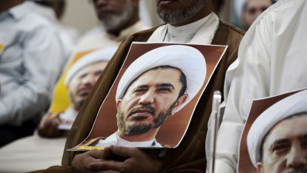 A Bahraini man holds a placard bearing the portrait of Sheikh Ali Salman, head of the Shia opposition movement Al-Wefaq, during a protest against his arrest outside Manama. (AFP/Mohammed al-Shaikh)