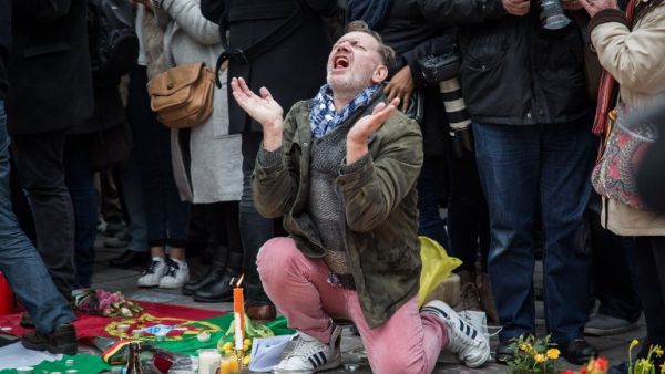 A man reacts as people gather to observe a minute of silence in memory of the victims of the Brussels airport and metro bombings, on the Place de la Bourse in central Brussels, on March 23, 2016, a day after the triple blasts killed some 30 people and left around 250 injured. (AFP/Aurore Belot) A man reacts as people gather to observe a minute of silence in memory of the victims of the Brussels airport and metro bombings, on the Place de la Bourse in central Brussels, on March 23, 2016, a day after the triple blasts killed some 30 people and left around 250 injured. (AFP/Aurore Belot)
