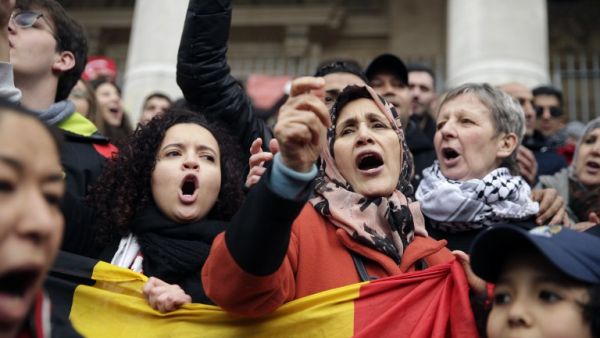 People sing as they gather around a makeshift memorial at the Place de la Bourse in Brussels on March 23, 2016, a day after blasts hit the Belgian capital. (AFP/Kenzo Tribouillard)