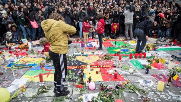 People gather to observe a minute of silence in memory of the victims of the Brussels airport and metro bombings, on the Place de la Bourse in central Brussels, on March 23, 2016, a day after the triple blasts killed some 30 people and left around 250 injured. (AFP/Aurore Belot)