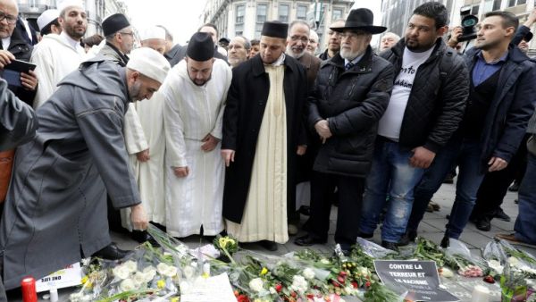 People leave flowers at a make-shirt memorial following a commemorative march at La Bourse in Brussels on March 22, 2017 as Belgium marks the first anniversary of the twin Brussels attacks by Islamic extremists. (AFP/Thierry Roge)