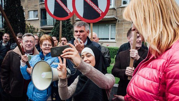 Far-right protesters in Belgium didn't know how to react when a young woman wearing a hijab approached them to take a selfie. (Twitter/Jurgen Augusteyns)