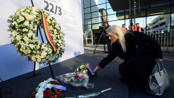 A woman places flowers at Brussels' international airport in Zaventem during a memorial ceremony to mark the first anniversary of the twin Brussels attacks on March 22, 2017. (Emmanuel Dunand)