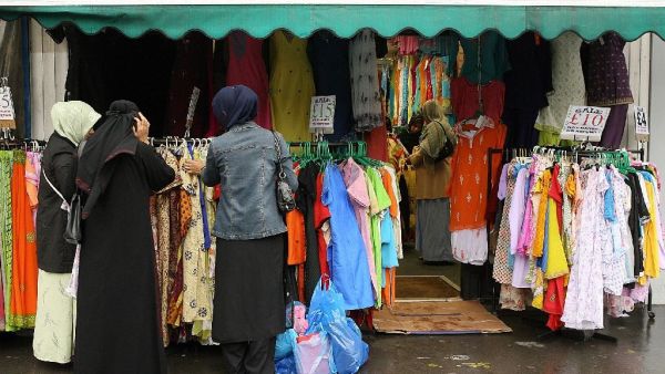 Women shop for clothes at a market in the UK (AFP/John D McHugh)