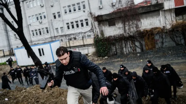 Turkish anti-riot policemen take cover during clashes with two female assailants, on March 3, 2016, in the Bayrampasa neighborhood in Istanbul, after the two women hurled grenades and opened fire at an Istanbul police station. (AFP/Ozan Kose)