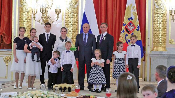 President Vladimir Putin poses for photos with Russia’s biggest families (Twitter)