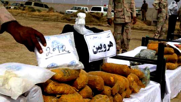 An Iranian officer displays packages of seized Afghan-made drugs (AFP)