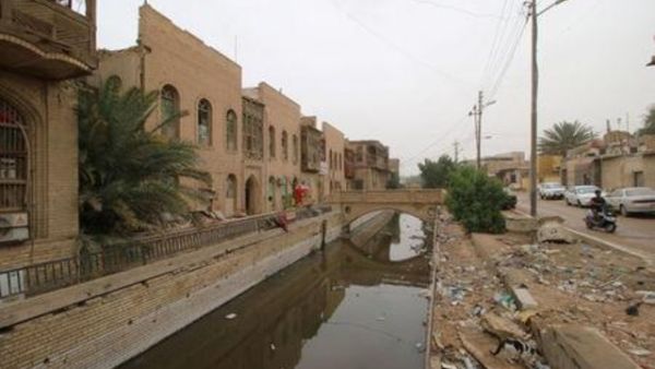 نفايات ملقاة في نهر بالقرب من بيوت أثرية على الطراز العثماني في البصرة


