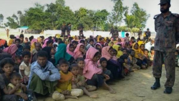 مسلمون روهينغا من بورما حاولوا عبور نهر ناف الى بنغلادش هربا من العنف الطائفي، يجلسون تحت انظار مسؤولي الامن البنغلادشيين في تكناف

