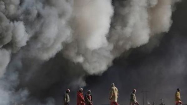 عمال نفط عراقيون قرب حقول نفط أشعلها تنظيم الدولة الإسلامية في القيارة إلى الجنوب من الموصل
