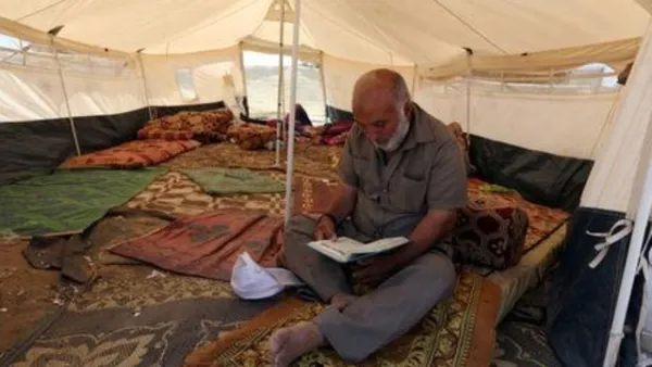 رجل فلسطيني يقرأ القرآن داخل خيمة خلال شهر رمضان في مخيم احتجاج قرب حدود إسرائيل مع قطاع غزة
