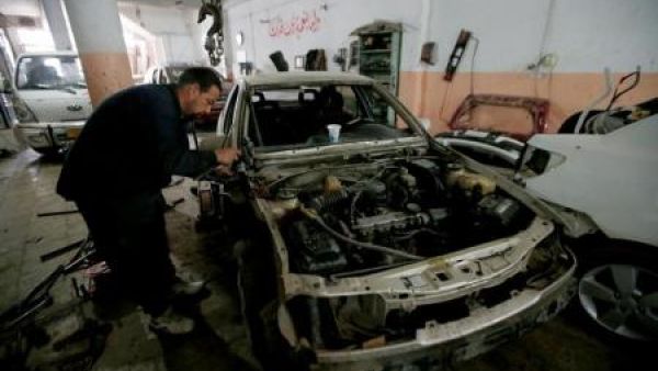 عامل يصلح سيارة في الموصل
