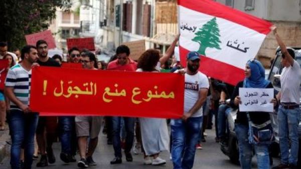 أشخاص يشاركون في مظاهرة ضد الطائفية وتدعو لإلغاء حظر التجول المفروض على اللاجئين السوريين في بيروت
