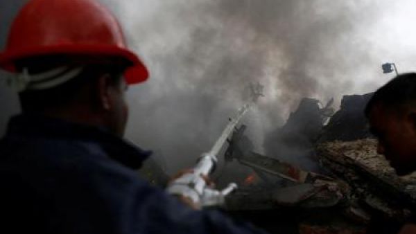 رجل إطفاء يشارك في إخماد حريق بمصنع للملابس خارج داكا يوم السبت
