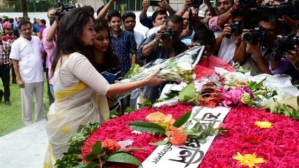 امرأة تضع باقة من الزهور تحية لارواح 22 قتيلا سقطوا في هجوم على مقهى في عاصمة بنغلادش دكا

