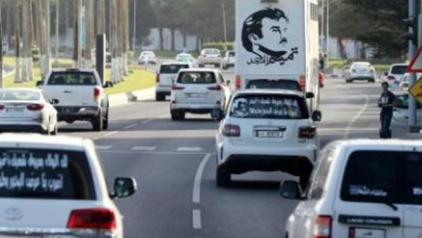 صور أمير قطر الشيخ تميم بن حمد آل ثاني على السيارات في أحد شوارع الدوحة

