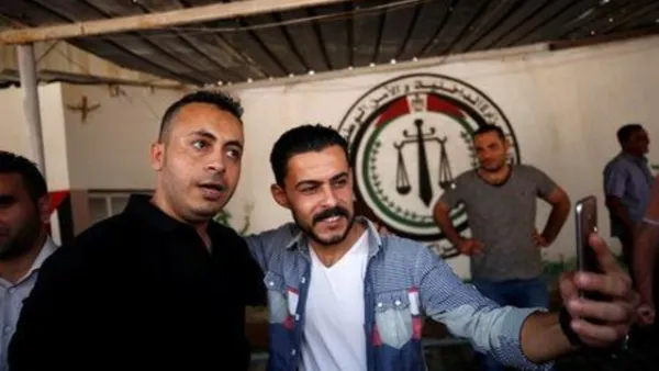 فلسطيني يلتقط صورة مع رجل من حركة فتح لدى الافراج عنه من سجن تديره حركة حماس في اطار جهود المصالحة بمدينة غزة 
