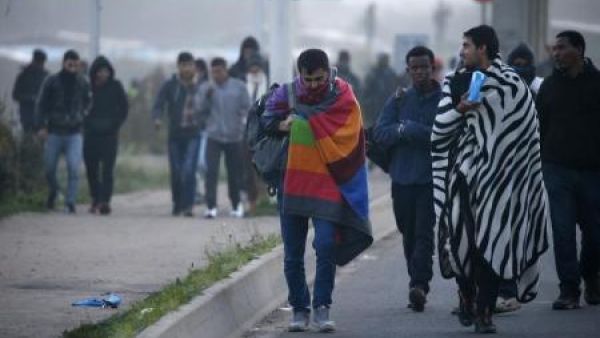 لاجئون يخملون أمتعتهم في ثاني أيام عملية نقلهم إلى سكن مؤقت في مراكز بفرنسا خلال أعمال هدم مخيم "الغابة" للمهاجرين في كاليه يوم الثلاثاء
