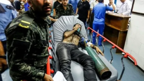 عناصر في حركة حماس ينقلون فلسطينيا اصيب في الغارات الاسرائيلية لتلقي عناية طبية في مستشفى الشفاء في غزة
