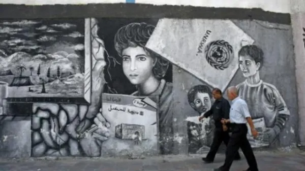 رجلان فلسطينيان أمام المركز الرئيسي لوكالة الاونروا في قطاع غزة
