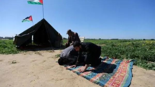 فلسطينيون يؤدون الصلاة بجوار خيمة بالقرب من الحدود مع اسرائيل

