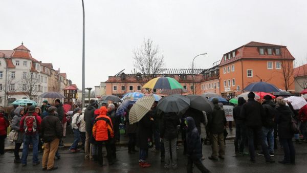 People demonstrate on February 21, 2016 in solidarity with refugees in front of a former hotel being converted into a home for asylum seekers and partly destroyed by a fire in Bautzen, eastern Germany. (AFP/Christian Essler)