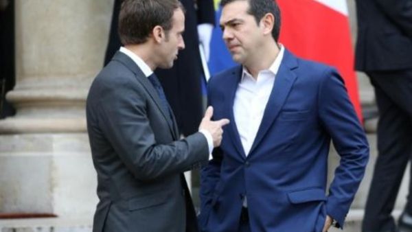 رئيس وزراء اليونان اليكسيس تسيبراس (يمين) يتحدث إلى الرئيس الفرنسي ايمانويل ماكرون قبل مغادرته قصر الإليزيه في باريس

