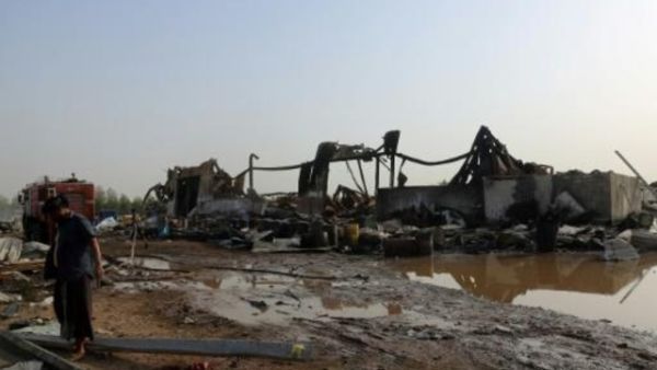 يمنيون يتفقدون الاضرار في مصنع في مرفأ الحديدة على البحر الأحمر استهدفه قصف للتحالف الذي تقوده السعودية

