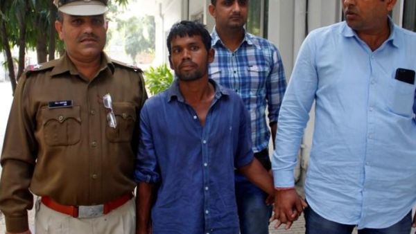 من الشرطة يقتاد رجلًا متهم باغتصاب وقتل أطفال في مركز للشرطة بضواحي نيودلهي
