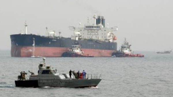 زورق دورية إيران في مياه الخليج على مقربة من ناقلة نفط تستعد للرسو في ميناء جزيرة خرج النفطي

