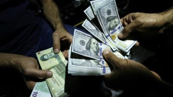 رجل يستبدل ريالات إيرانية بدولارات

