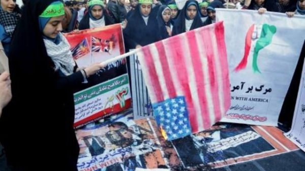 فتاة ايرانية تحرق علما اميركيا امام مقر السفارة الاميركية سابقا في طهران
