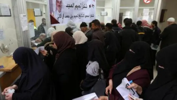 موظفون فلسطينيون مُعينون من قبل حماس ينتظرون لصرف رواتبهم المقدمة من قطر في خان يونس يوم الجمعة
