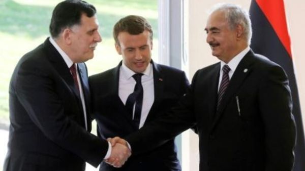 الرئيس الفرنسي ايمانويل ماكرون يتوسط مصافحة بين رئيس حكومة الوفاق الوطني الليبية فايز السراج وخصمه المشير خليفة حفتر، الرجل القوي في شرق ليبيا
