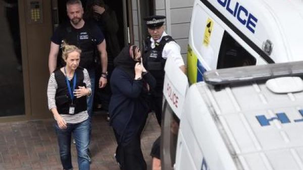 عناصر من الشرطة يقتادون امراة إلى سيارة شرطة خلال مداهمة في باركينج بشرق لندن يوم الاحد
