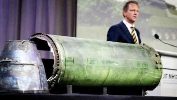 كبير المحققين فريد فيستربيكي يعرض جزء من صاروخ من نوع بوك في مؤتمر صحافي
