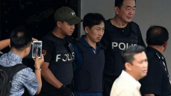 الكوري الشمالي ري جونغ شول (وسط) بين عناصر الشرطة بعد اخلاء سبيله في مركز الشرطة في سيبانغ

