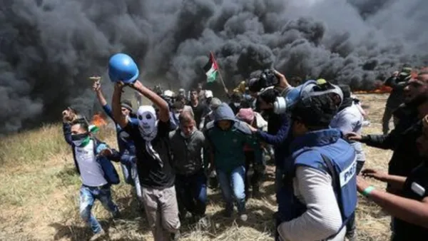 فلسطينيون يقومون بإجلاء الصحفي الفلسطيني ياسر مرتجى الذي أصيب بجروح مميتة أثناء تغطية الاشتباكات على الحدود بين إسرائيل
