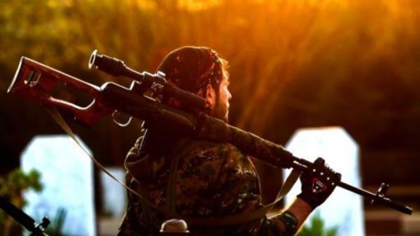 عنصر من قوات سوريا الديموقراطية خلال جنازة قيادي كردي في القامشلي
