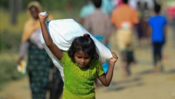 طفلة من اللاجئين الروهينغا تحمل مساعدات قي مخيم في منطقة اوخيا ببنغلادش
