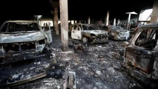 أشخاص يقفون في موقع غارة جوية قال شهود إن طائرة تابعة للتحالف الذي تقوده السعودية شنها على دار عزاء في صنعاء
