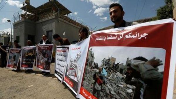 أشخاص يحملون لافتات تعرض ضحايا غارة جوية بقيادة السعودية خلال احتجاج أمام مكاتب الأمم المتحدة في صنعاء
