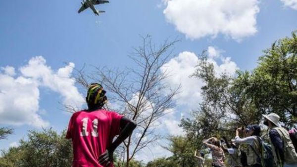 أناس يتابعون طائرة تقوم بإنزال مساعدات غذائية من برنامج الأغذية العالمي قرب بلدة كاتدالوك في ولاية جونقلي بجنوب السودان
