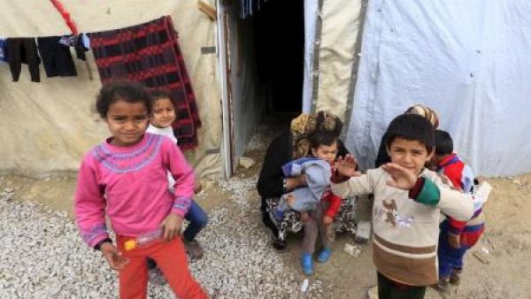 أطفال سوريون أمام خيمة في بير الياس بسهل البقاع اللبناني
